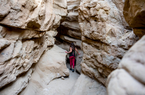 girl going through the slot canyon